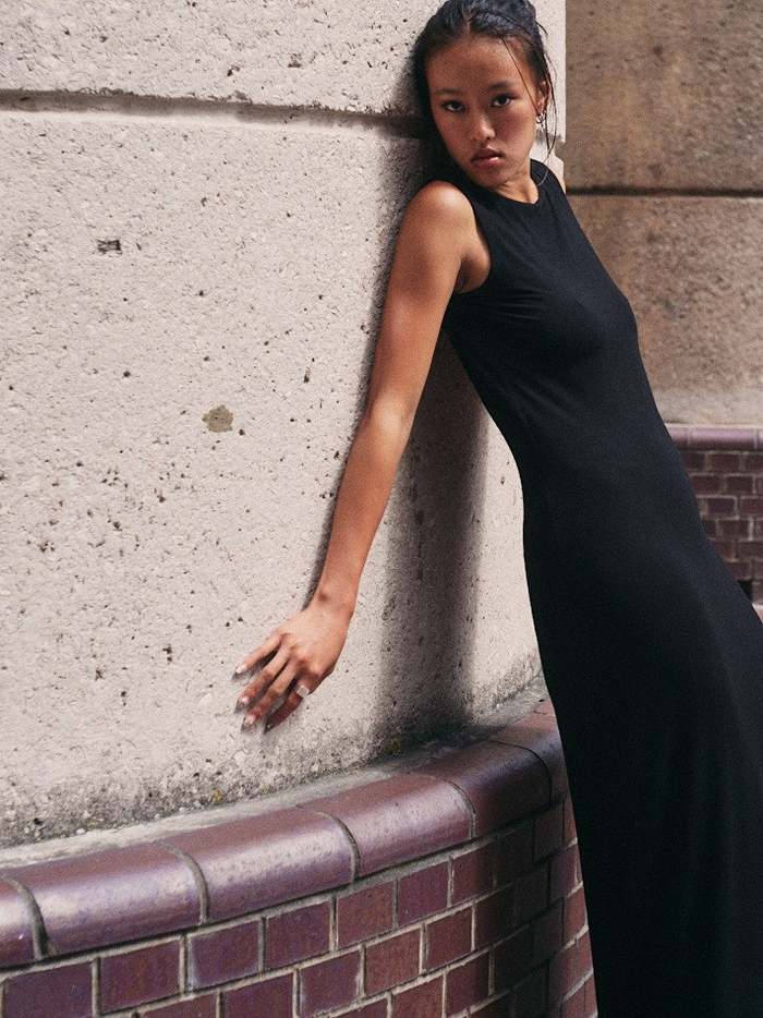 Leaning against a concrete wall in afternoon light