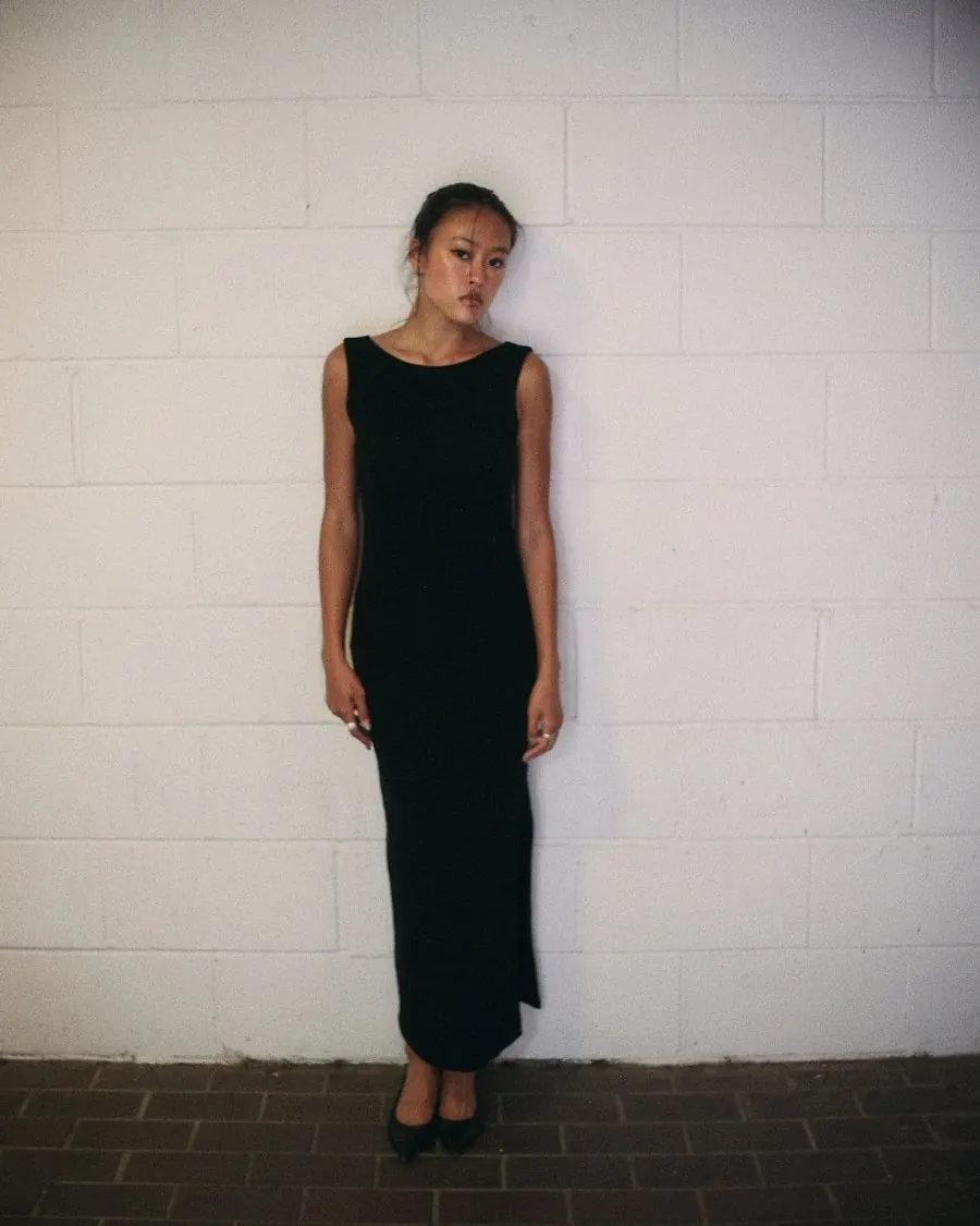 The Kallaus Dress worn front on, full length: straight neckline, column silhouette, side split at the hem.