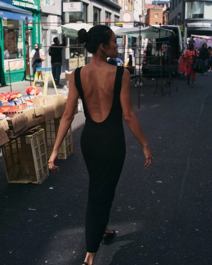 Walking through a street market, the full length of the dress from behind.